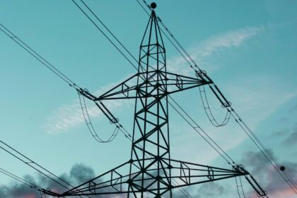 High voltage transmission towers carrying lines across open country