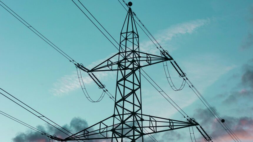 High voltage transmission towers carrying lines across open country