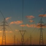 High-voltage transmission towers and lines at sunset