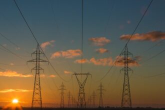 High-voltage transmission towers and lines at sunset
