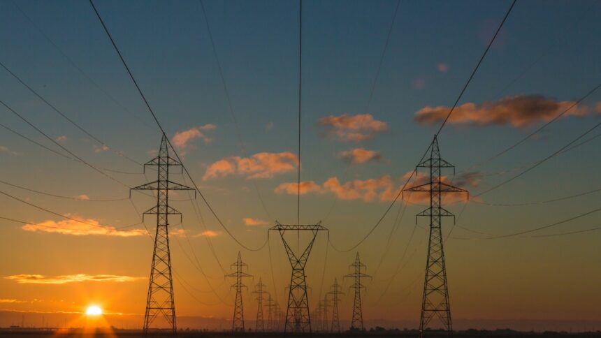 High-voltage transmission towers and lines at sunset