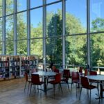 A library interior with tall windows and long study tables