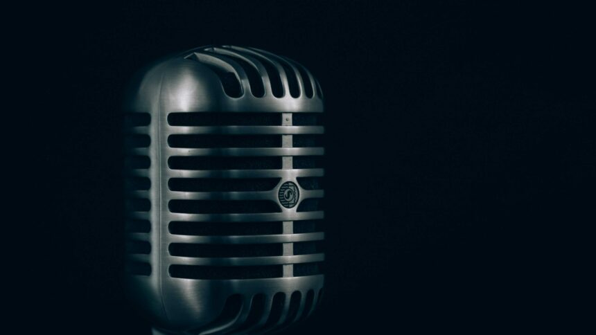 A vintage chrome microphone against a dark background