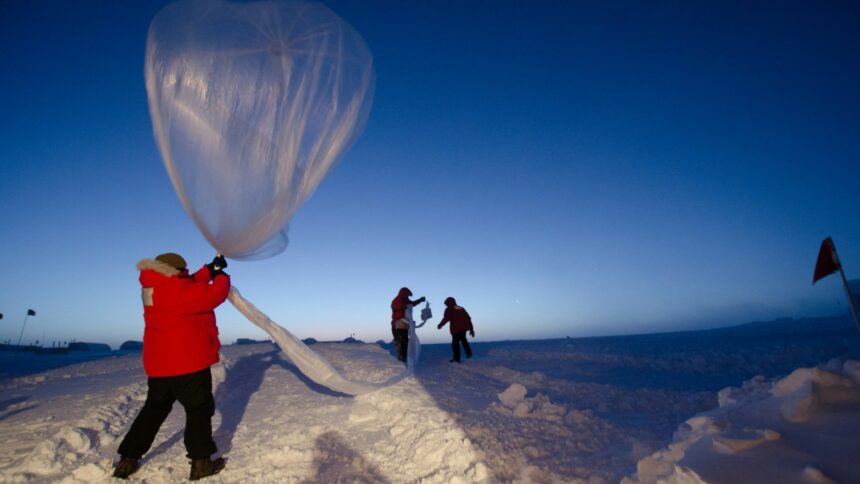 A weather balloon carrying an instrument package being launched by hand