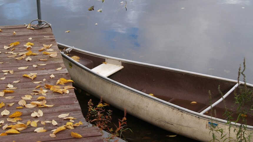 Canoe resting at a wooden dock in autumn light