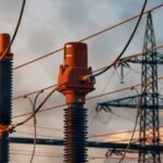 Substation insulators and power lines against an evening sky