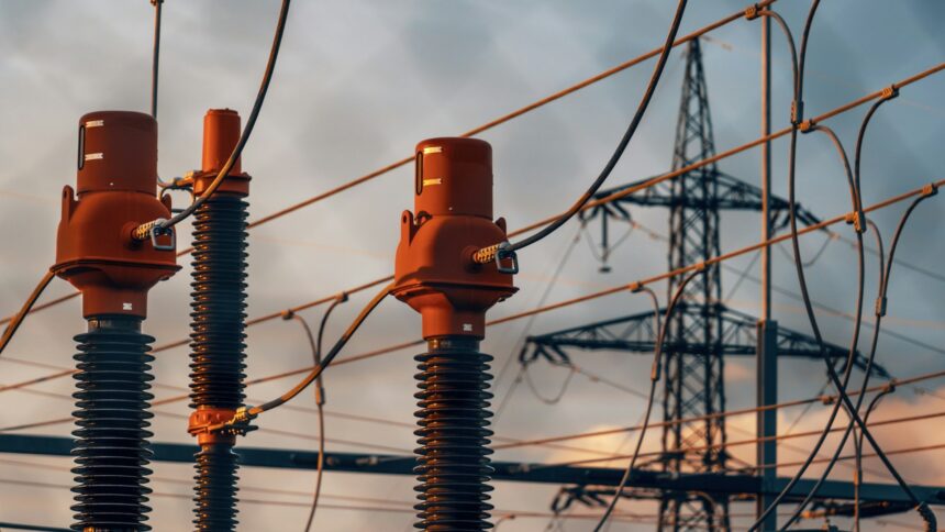 Substation insulators and power lines against an evening sky