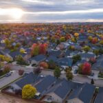 Aerial view of a residential neighbourhood with autumn trees at sunset