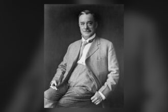 Black and white portrait of a seated man in a suit, Bob Edwards, editor of the Calgary Eye Opener