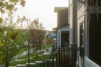 Row of townhouses with front porches on a tree-lined residential street in Calgary