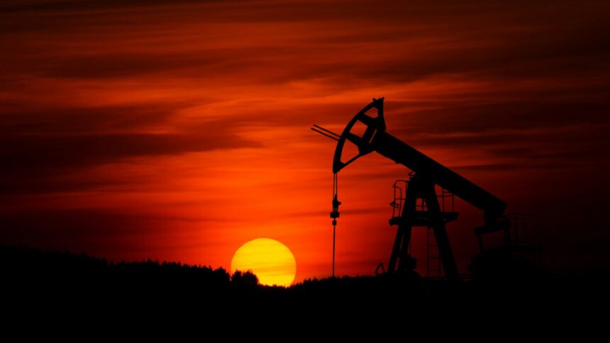 Silhouette of an oil pumpjack against a red sunset