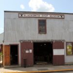 Front of the Lacombe Blacksmith Shop Museum, a corrugated metal building with a Blacksmith Shop Museum sign above open sliding doors