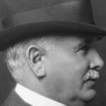 Black and white portrait of Patrick Burns in a hat and suit, shown in profile, photographed in 1927