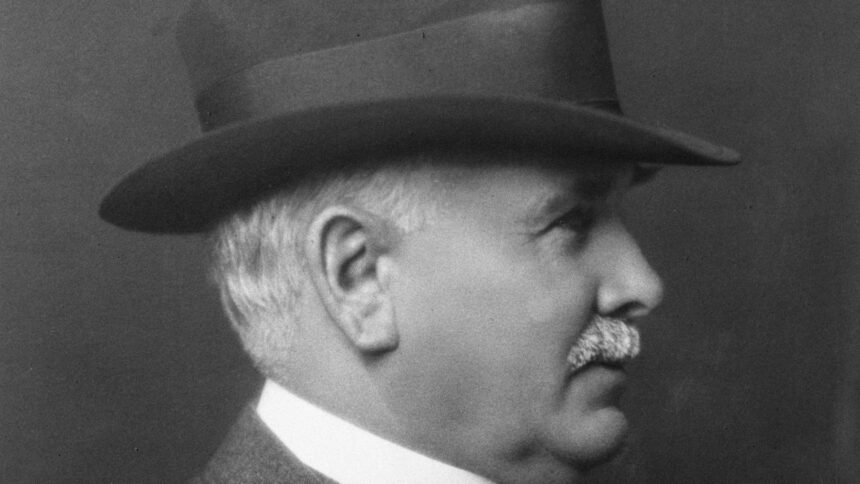 Black and white portrait of Patrick Burns in a hat and suit, shown in profile, photographed in 1927