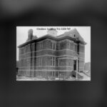 A two-storey brick library building with a tall entrance, standing alone on an open lot, in a black and white 1913 photograph