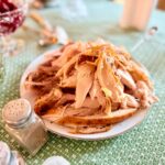 Platter of carved roast turkey on a Thanksgiving table with cranberry sauce and side dishes